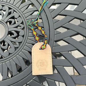 Consuela leather bag tag with friendship bracelet